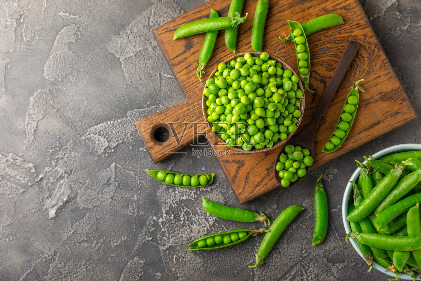 新鲜的绿豌豆荚和豌豆放在木质背景上。甜美的绿豌豆。绿豌豆豆类蔬菜。素食。健康蔬菜。留白空间。照片摄影图片