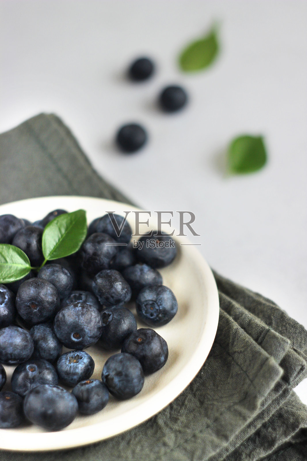 蓝莓放在桌子上的盘子里照片摄影图片