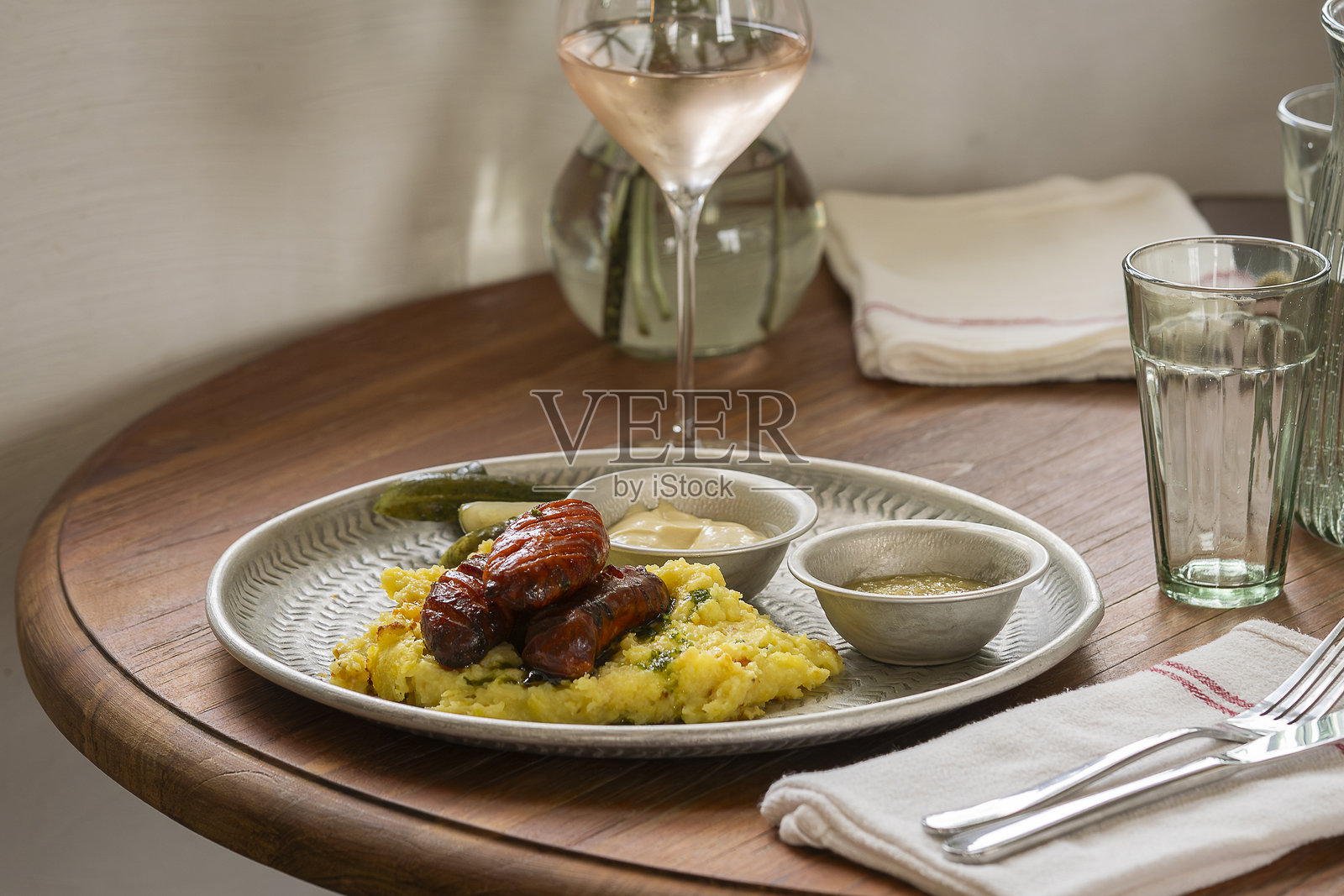 餐厅桌上摆放着香肠、土豆泥和香草。照片摄影图片