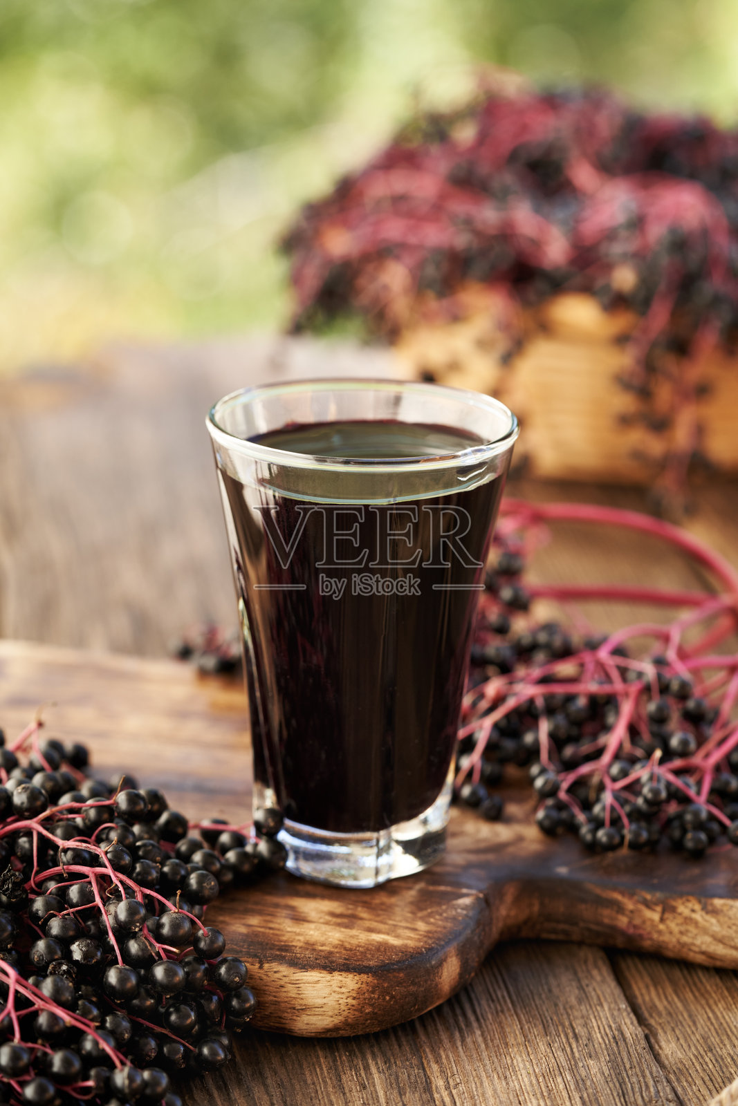 一杯黑接骨木糖浆，搭配新鲜的接骨木果，在夏日的户外。照片摄影图片