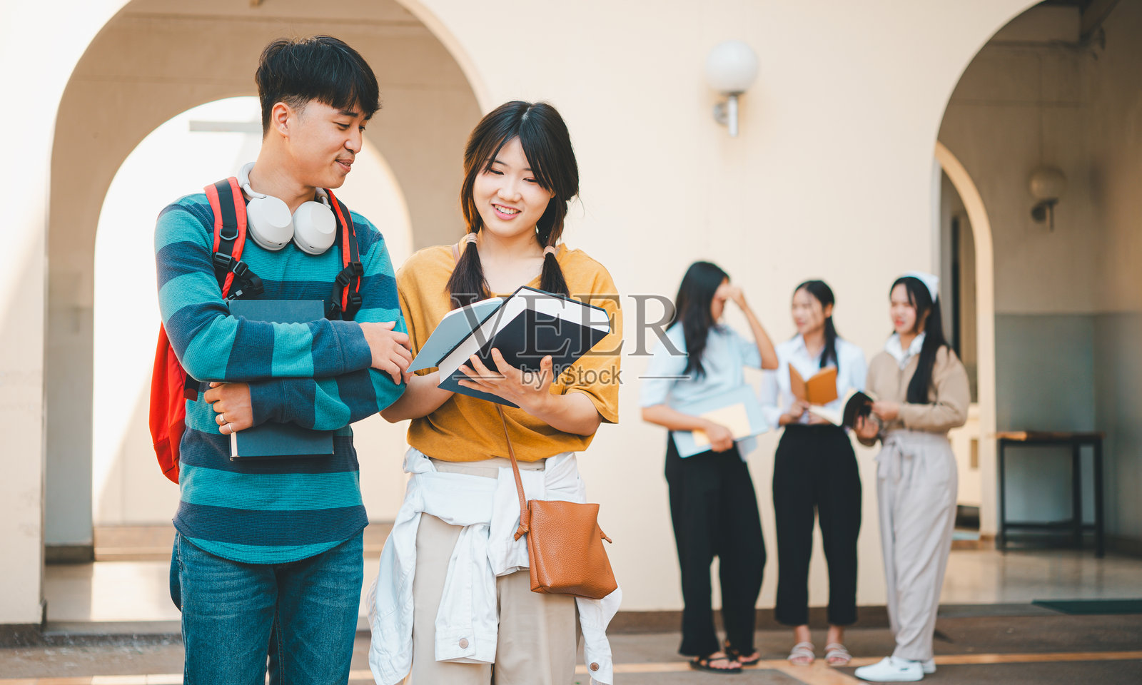 一群年轻的大学生在一起讨论概念和策略，合作进行研究计划，准备在笔记本电脑和平板电脑上进行演示。照片摄影图片