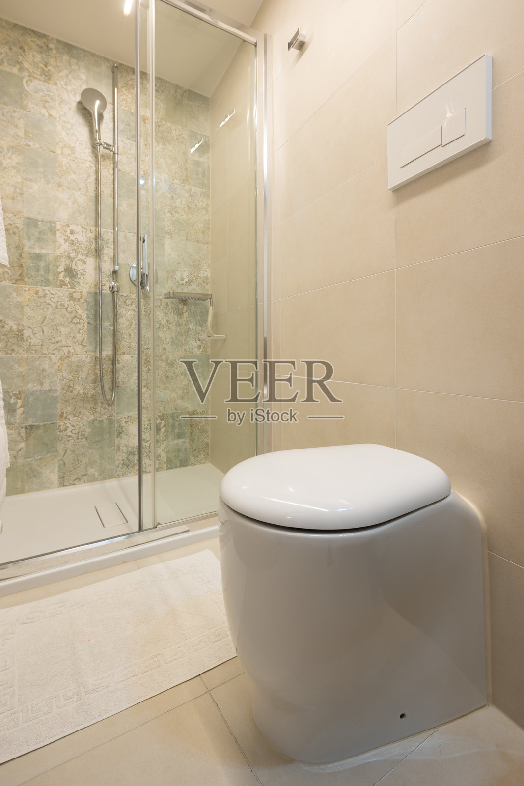 现代白色马桶的细节，背景是淋浴间。照片摄影图片