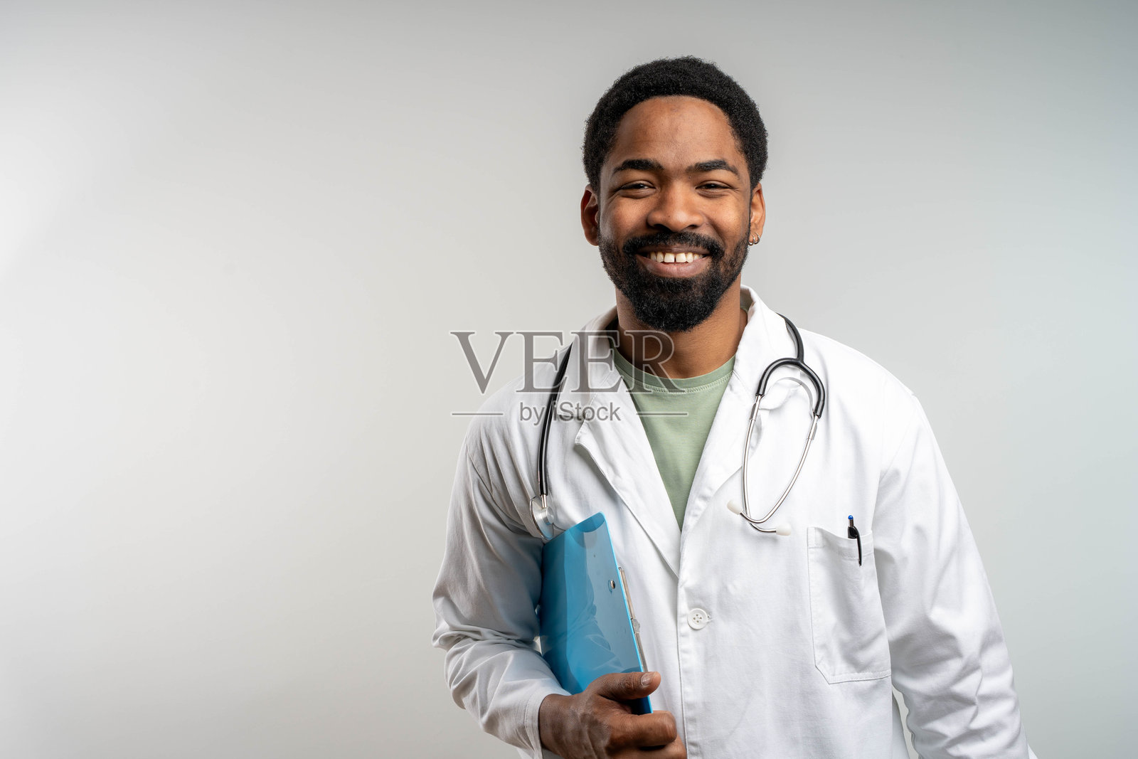 穿着白色制服的专业医生在镜头前摆姿势，手持夹板。照片摄影图片