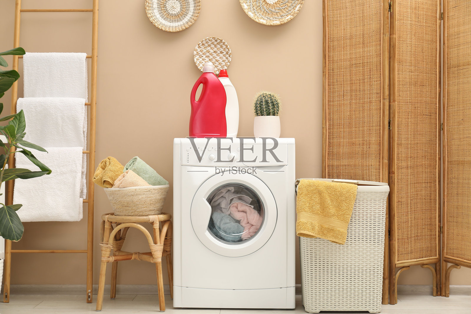 浴室里的藤编洗衣篮、洗衣机和洗涤剂照片摄影图片
