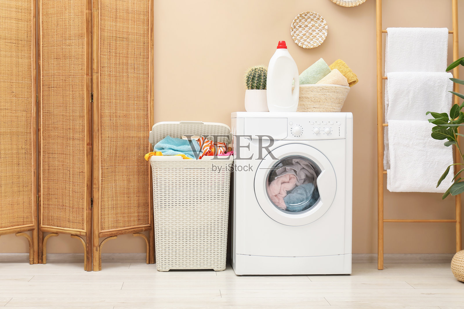 浴室里装满衣物的藤编篮子、洗衣机和洗涤剂照片摄影图片