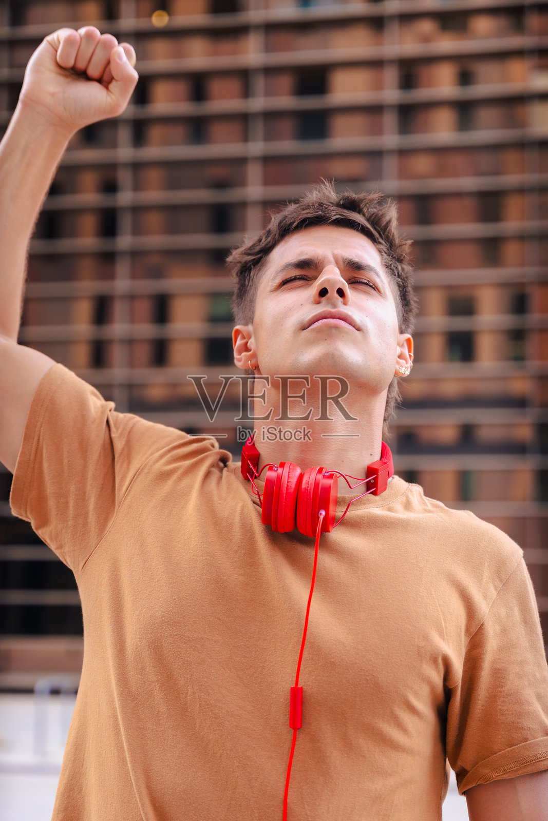 年轻男子在户外举起拳头，面露坚定表情照片摄影图片