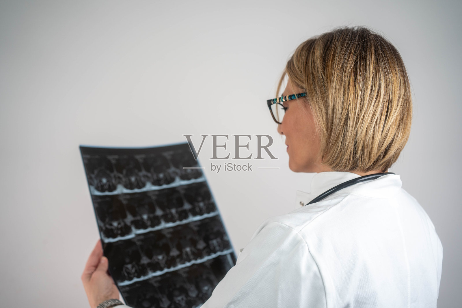 女医生正在分析患者脊柱的MRI扫描图像照片摄影图片