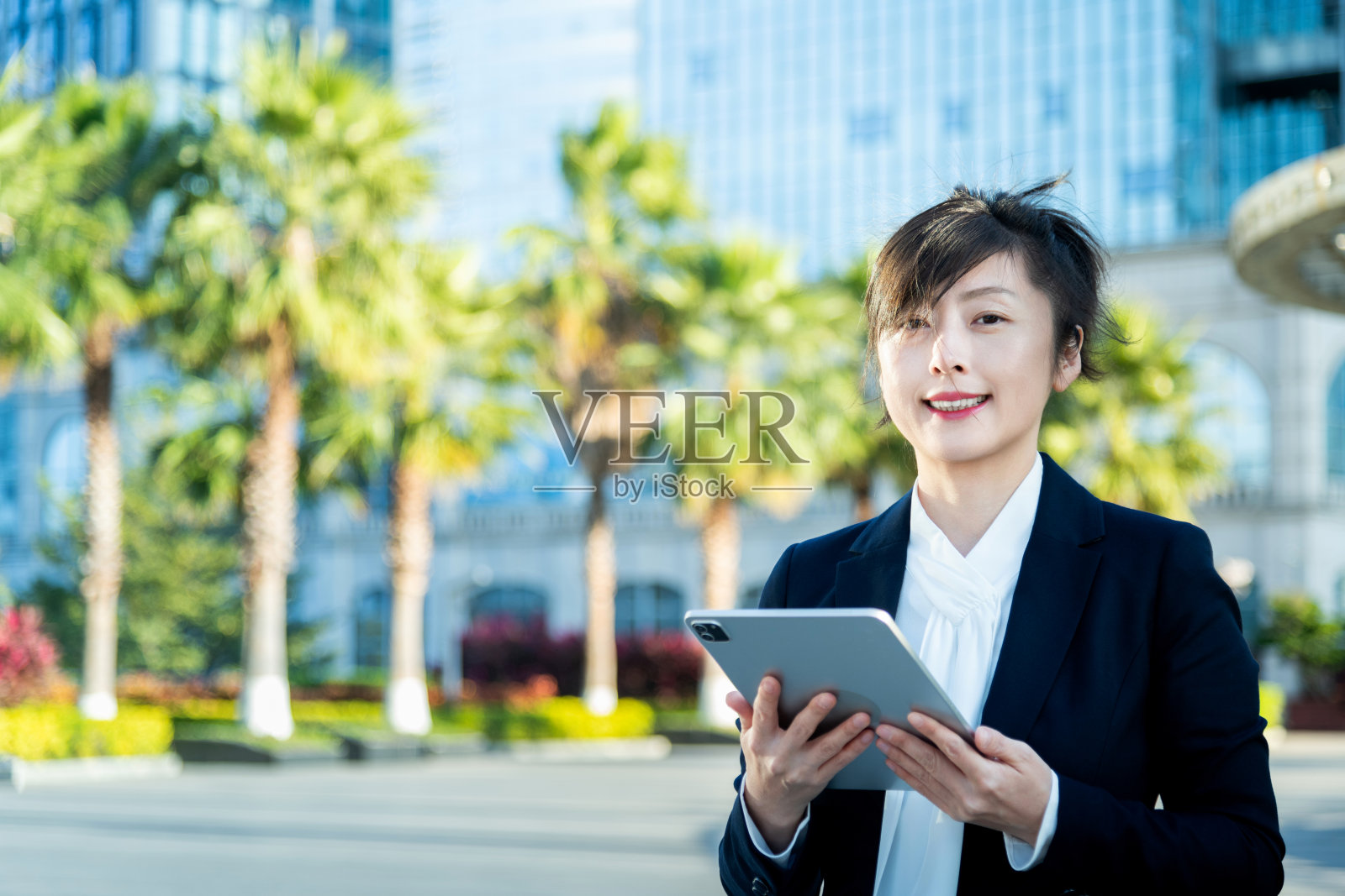 在办公大楼外使用数字平板的女商人照片摄影图片