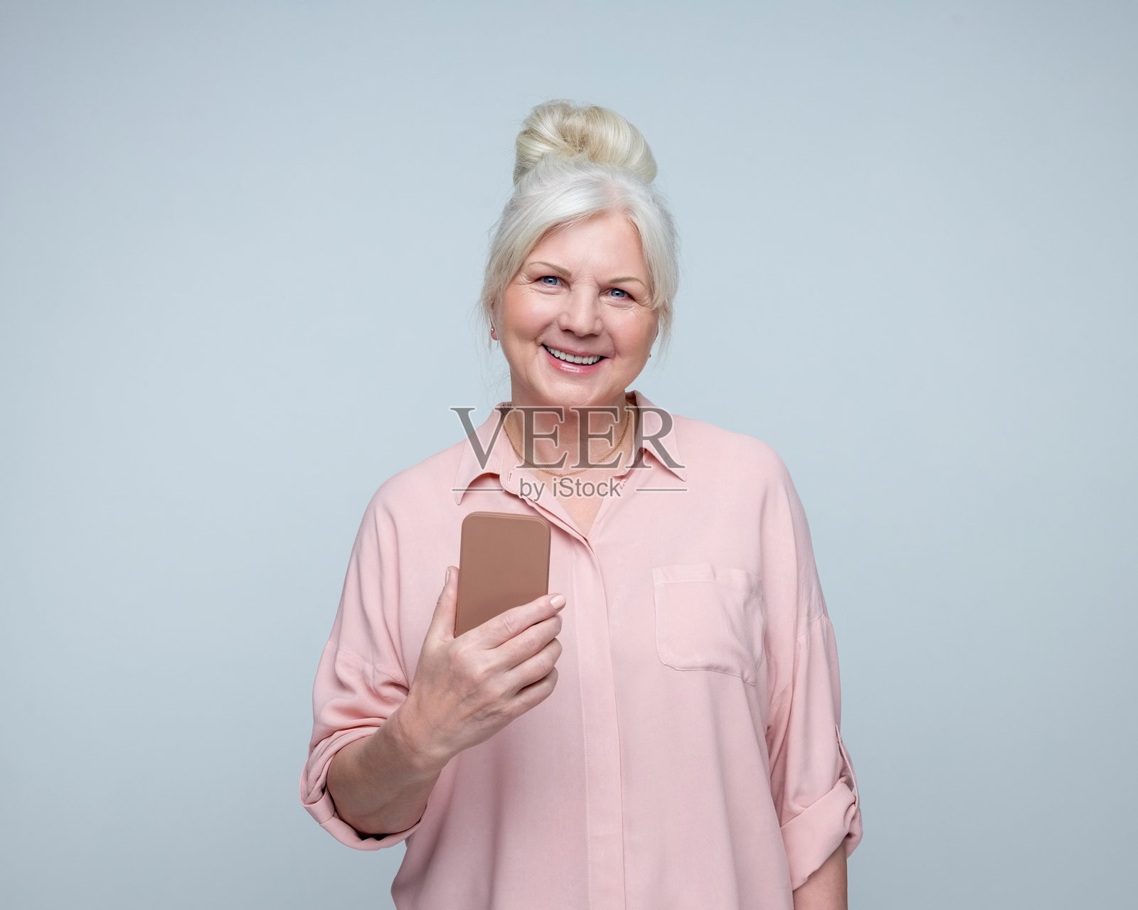 微笑的老年女士使用手机照片摄影图片