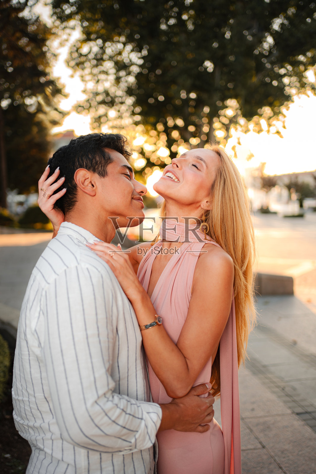 年轻情侣在公园的日落中相拥照片摄影图片