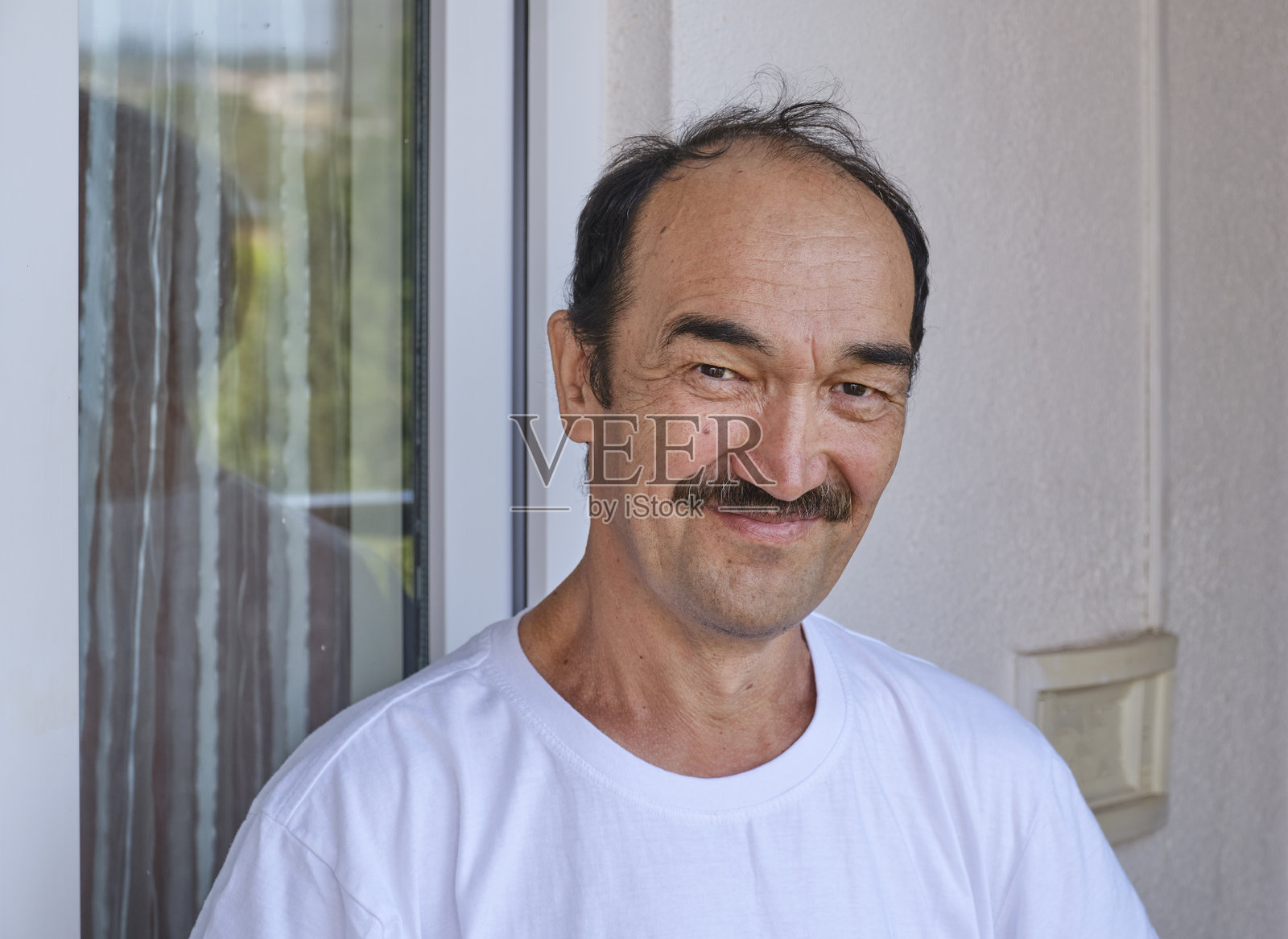 微笑的老年男子，留着胡子，穿着休闲的白色T恤。照片摄影图片