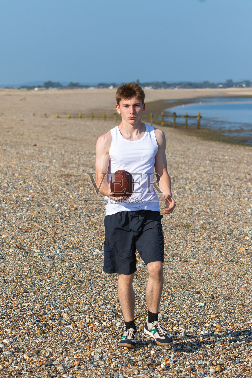 拿着美式足球的少年男孩照片摄影图片