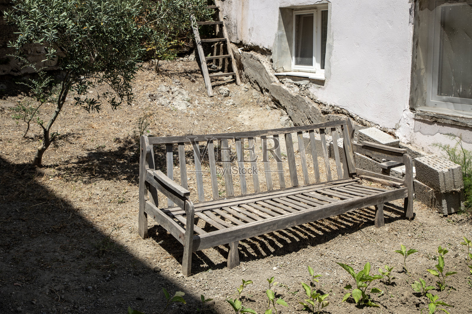阳光明媚的户外环境中的旧木花园长椅。照片摄影图片