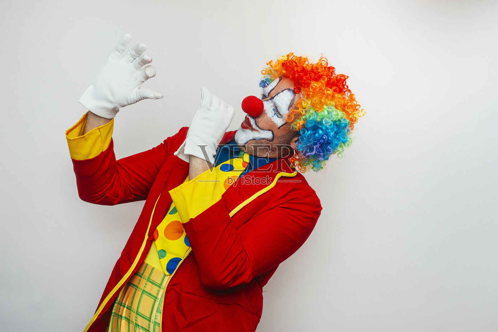 小丑表现得很害怕，双手举起。照片摄影图片