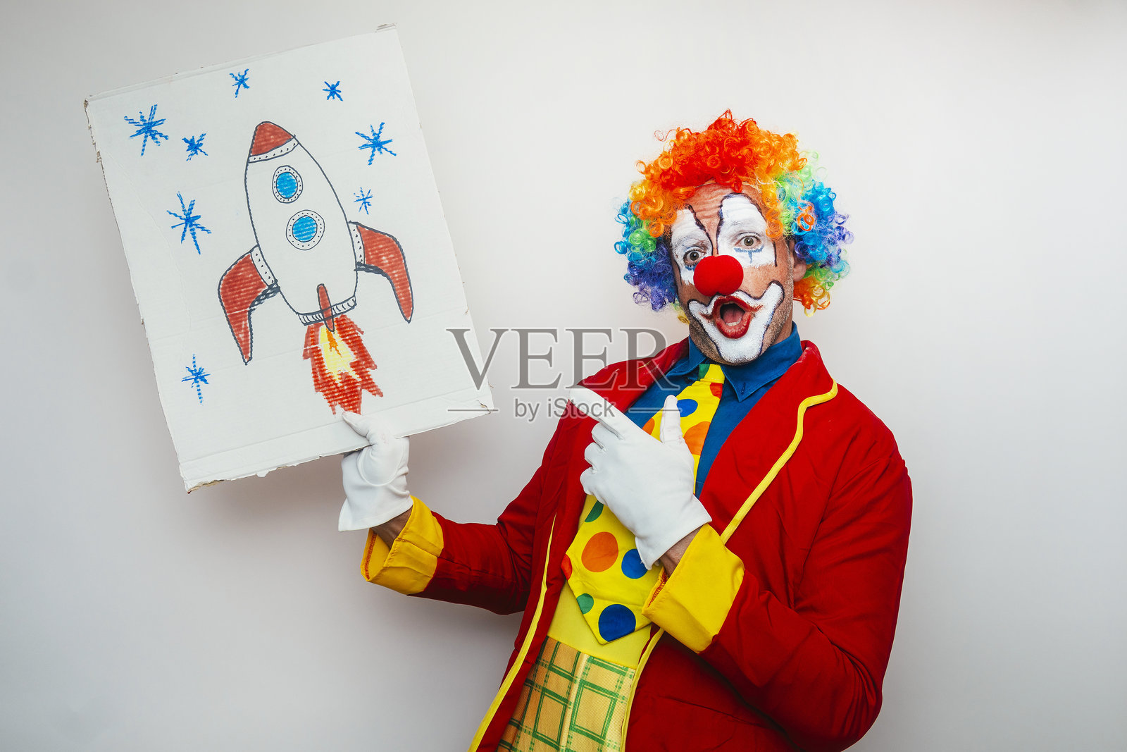 小丑手持画有图画的纸板照片摄影图片