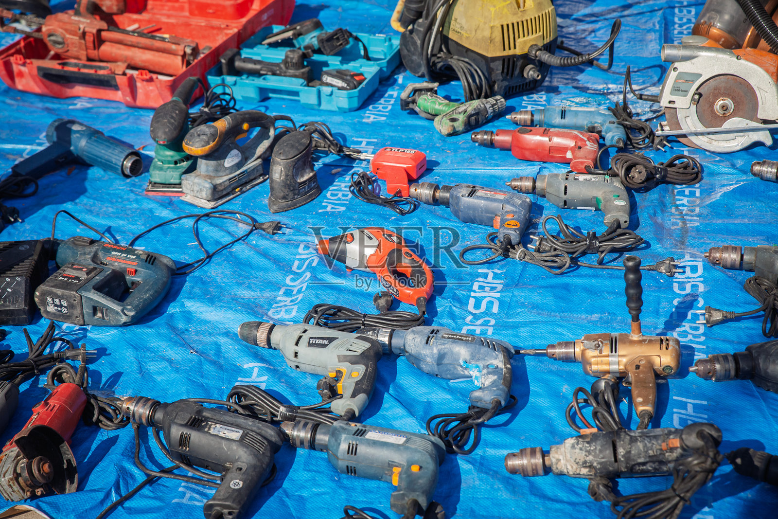 在奥布雷诺瓦茨的市场上出售的二手电动工具，展示了电钻和配件，代表了二手交易、修理文化和工具再利用。照片摄影图片