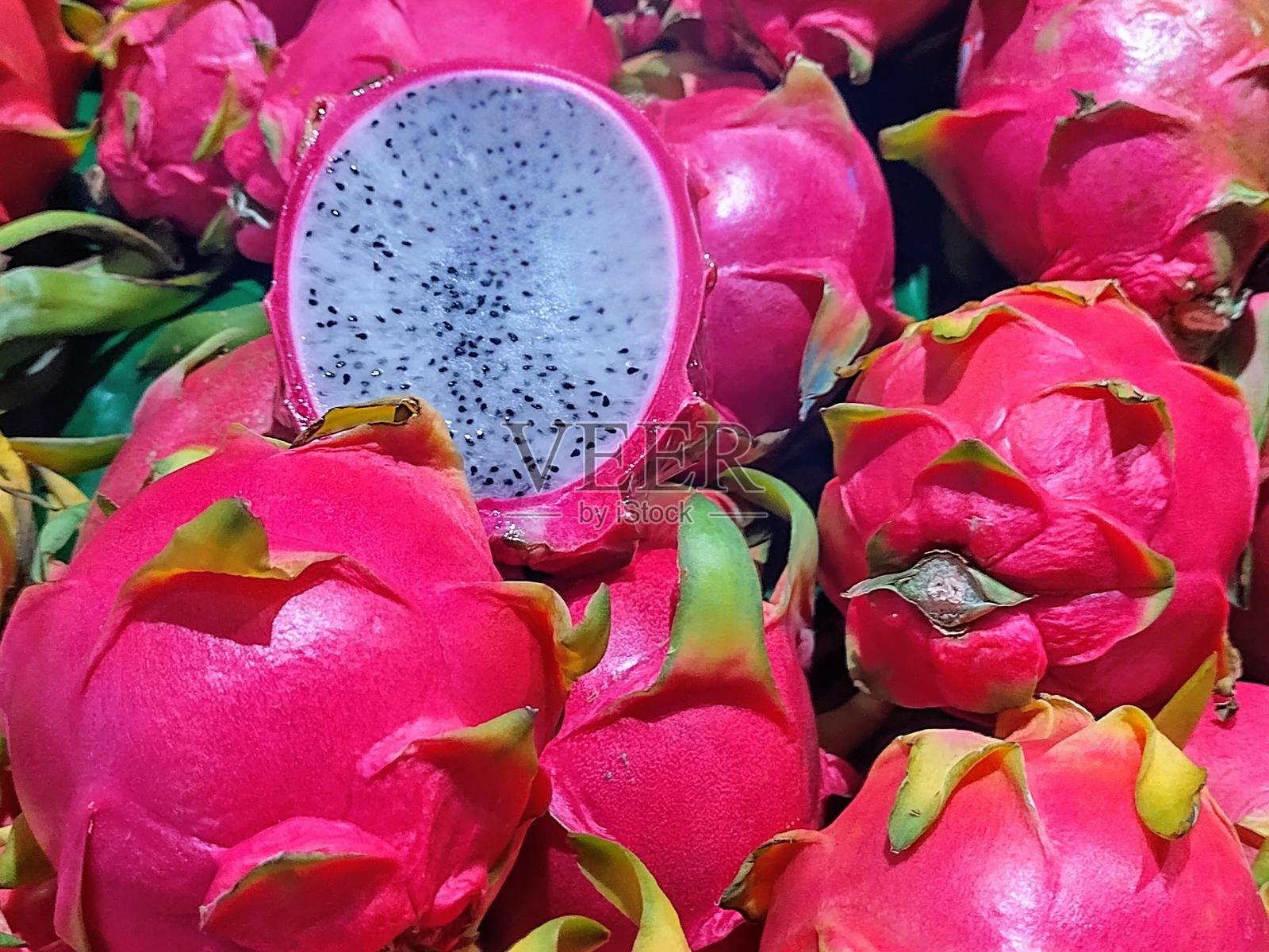 新鲜火龙果的特写视图，其中一个被切开。照片摄影图片