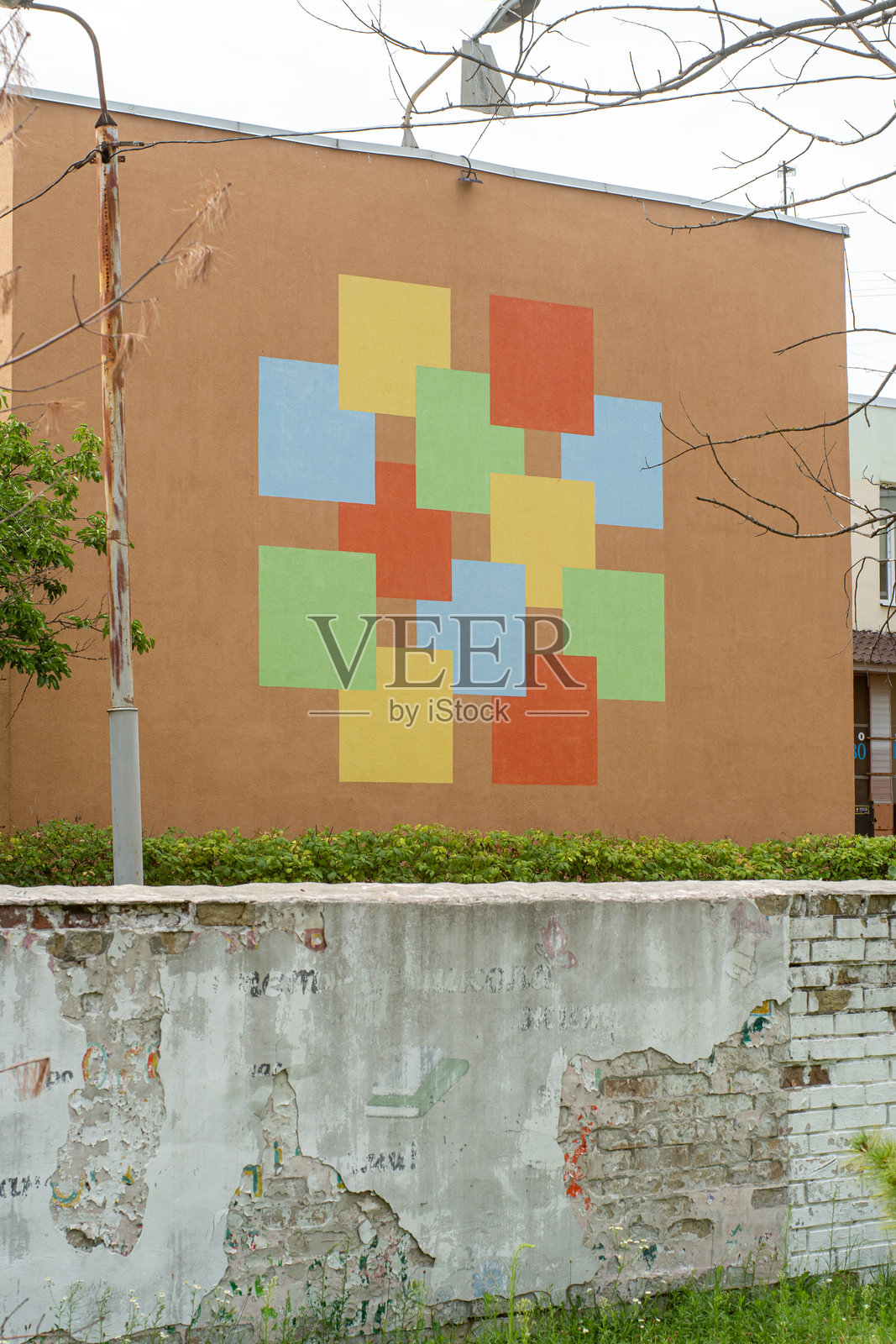 在乌克兰基辅Obolon区第11微区的一所1970年代幼儿园的绝缘墙上绘制的色彩斑斓的几何壁画。设计模仿了原始的釉面瓷砖图案。2025年7月26日。照片摄影图片