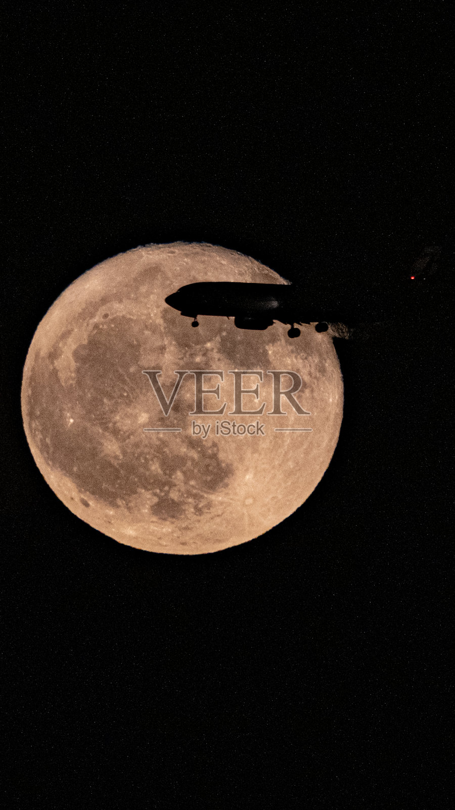 夜空中满月前的客机轮廓照片摄影图片