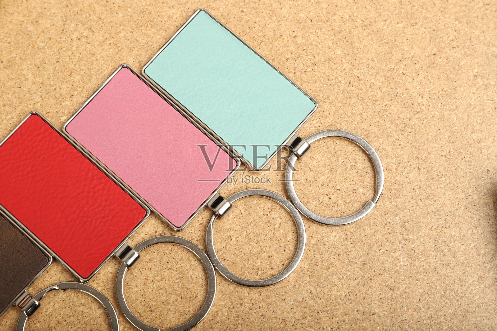 金属和皮革钥匙扣。彩色单面皮革；方形、矩形和圆形钥匙圈。概念拍摄。照片摄影图片