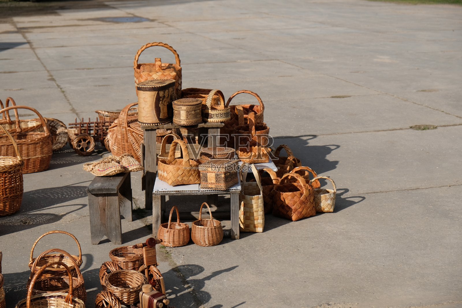 阳光明媚的天气中，手工编织的篮子在当地手工艺市场上展示。照片摄影图片
