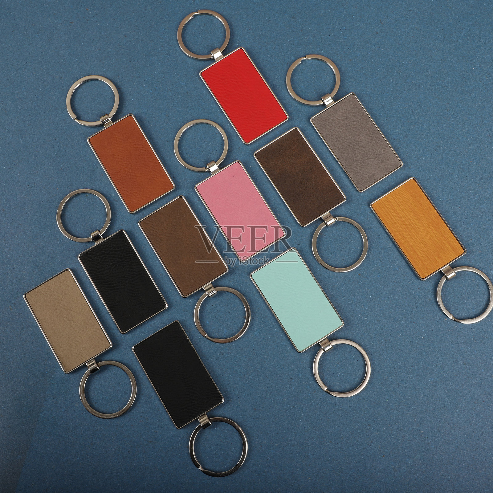 金属和皮革钥匙扣。彩色单面皮革；方形、矩形和圆形钥匙圈。概念拍摄。照片摄影图片