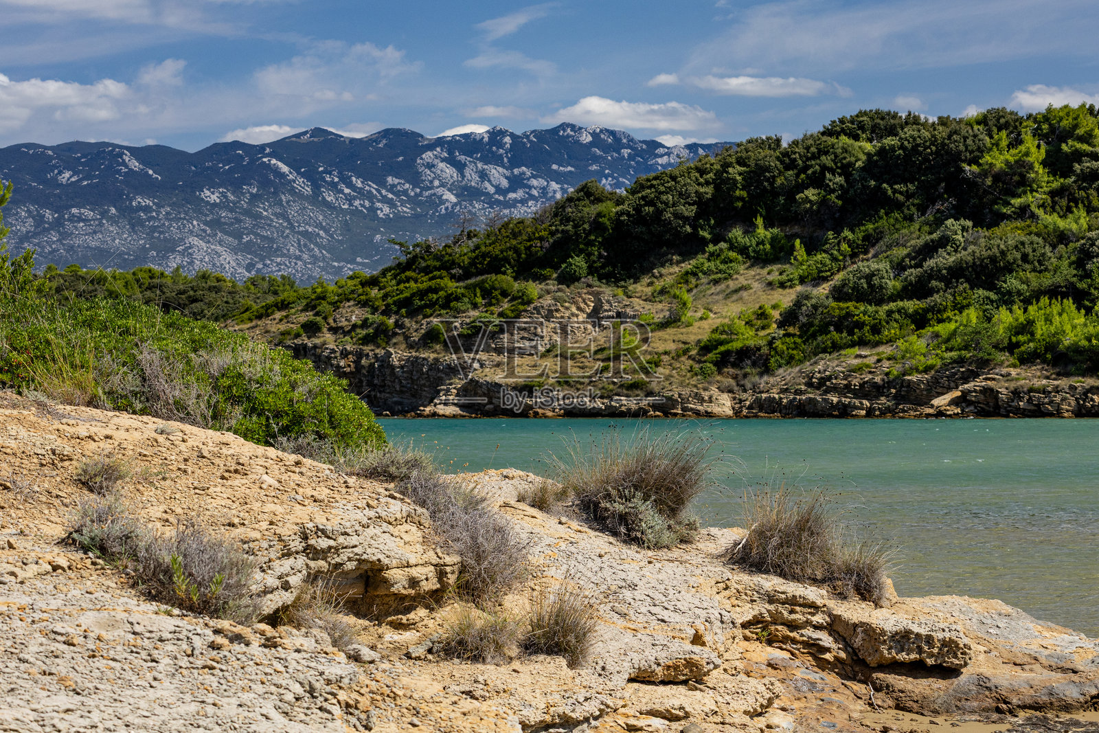 亚得里亚海的碧蓝海水，拉布岛的岩石海岸，阴云密布，威胁的天空，斯特鲁奇海滩照片摄影图片