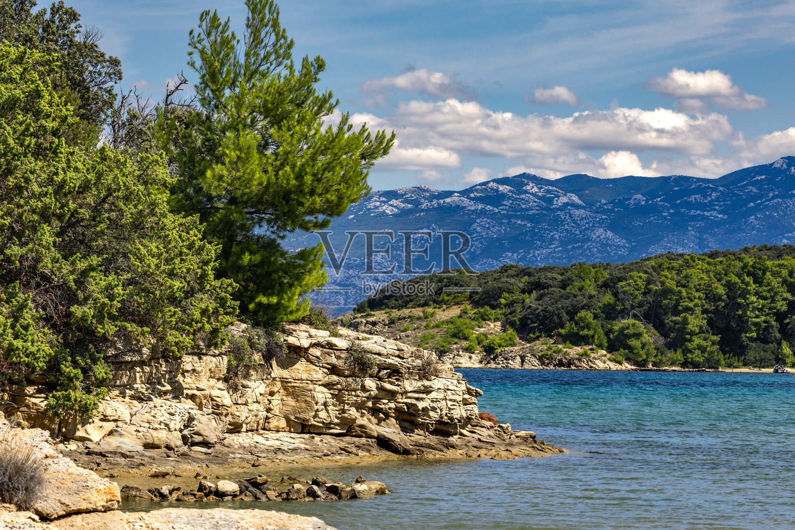 亚得里亚海的碧蓝海水，拉布岛的岩石海岸，阴云密布，威胁的天空，斯特鲁奇克海滩照片摄影图片