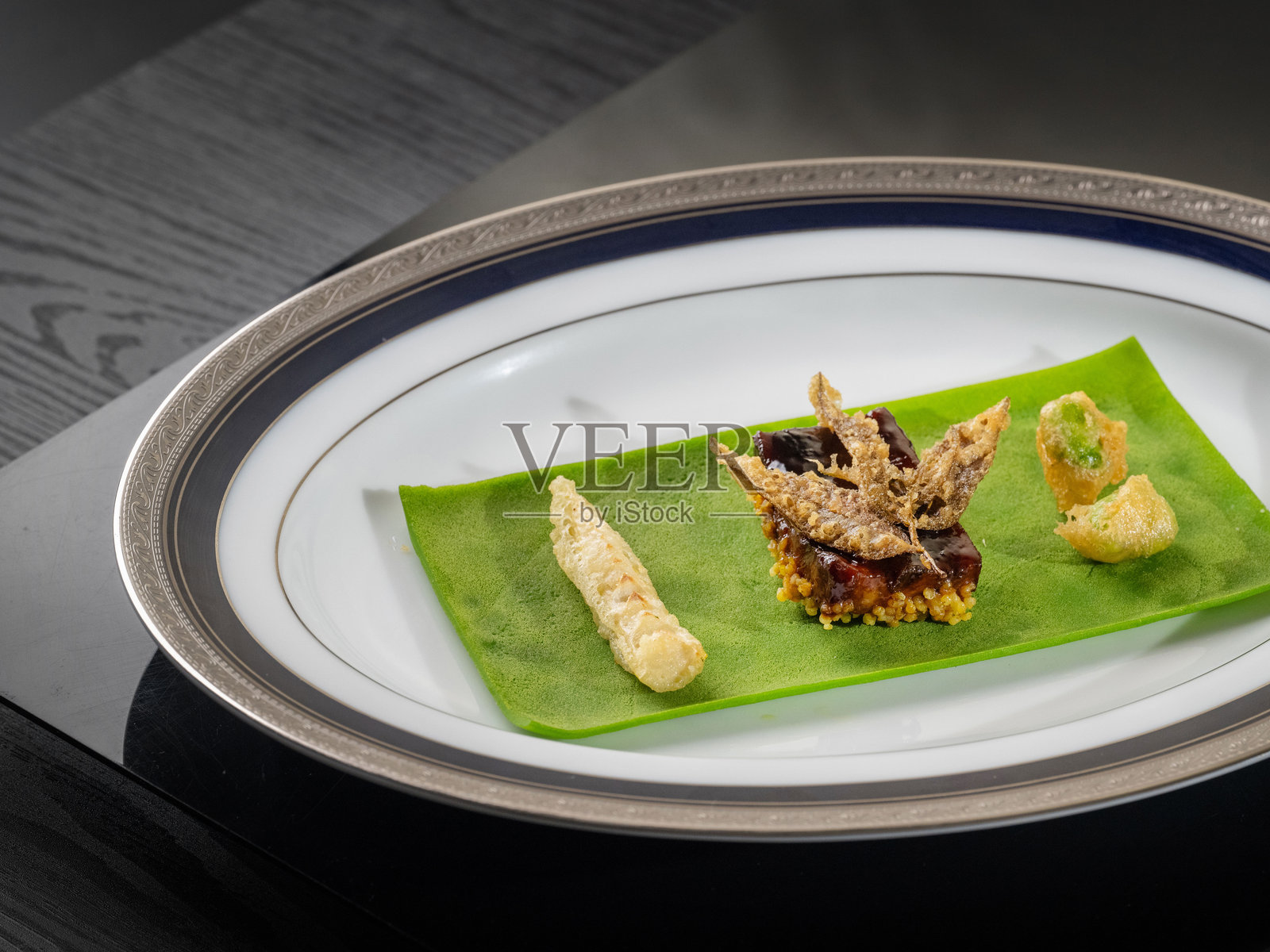 高档餐厅中的精致中餐，配有叶形炸物和蟹肉照片摄影图片