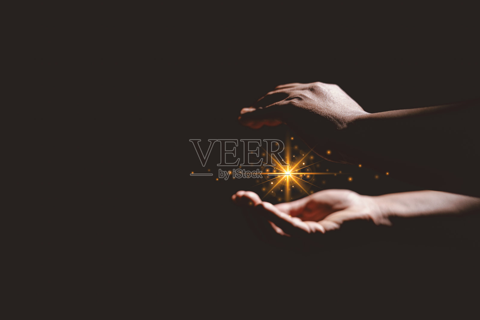 手握发光的光芒，象征着希望、治愈、信仰、灵感、精神能量、新的开始、奇迹、内在力量以及从黑暗到光明的积极转变。照片摄影图片