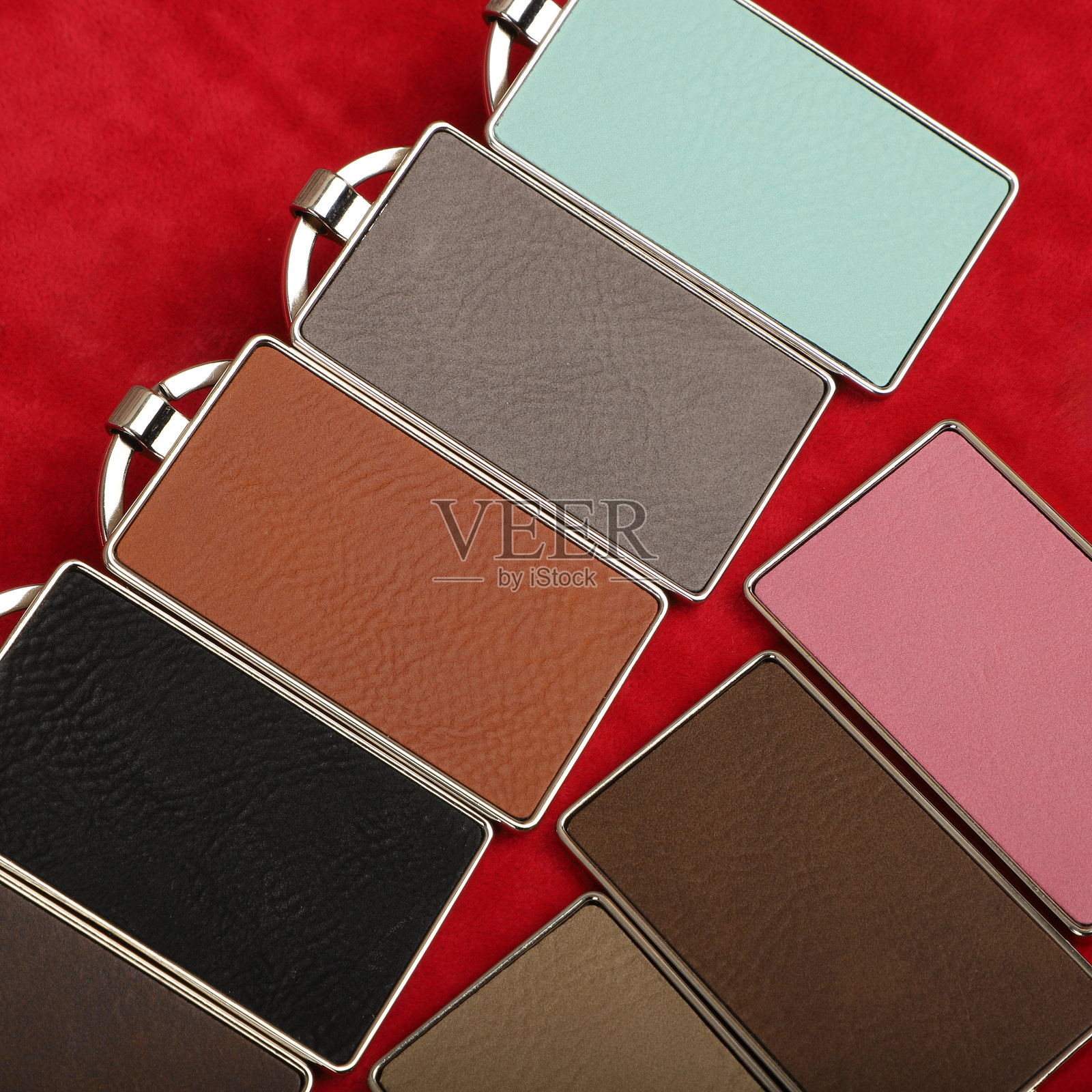 金属和皮革钥匙扣。彩色单面皮革；方形、矩形和圆形钥匙圈。概念拍摄。照片摄影图片