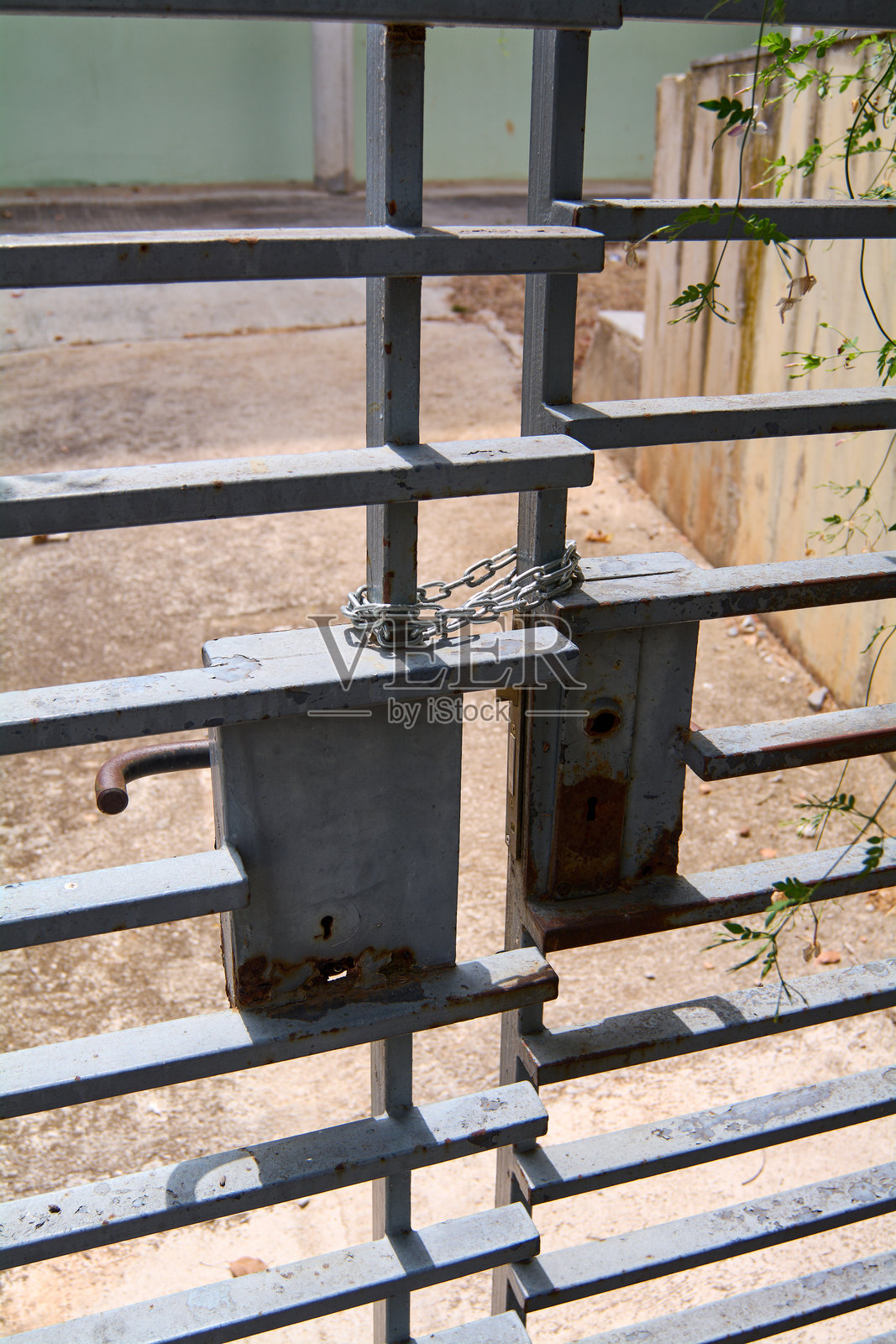 生锈的链条挂在一扇旧铁门上。照片摄影图片