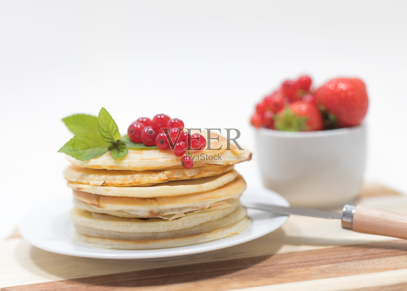 木板上放着红醋栗的煎饼堆特写照片摄影图片