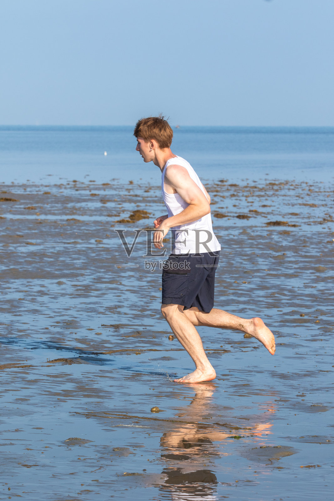 少年在海岸边奔跑照片摄影图片