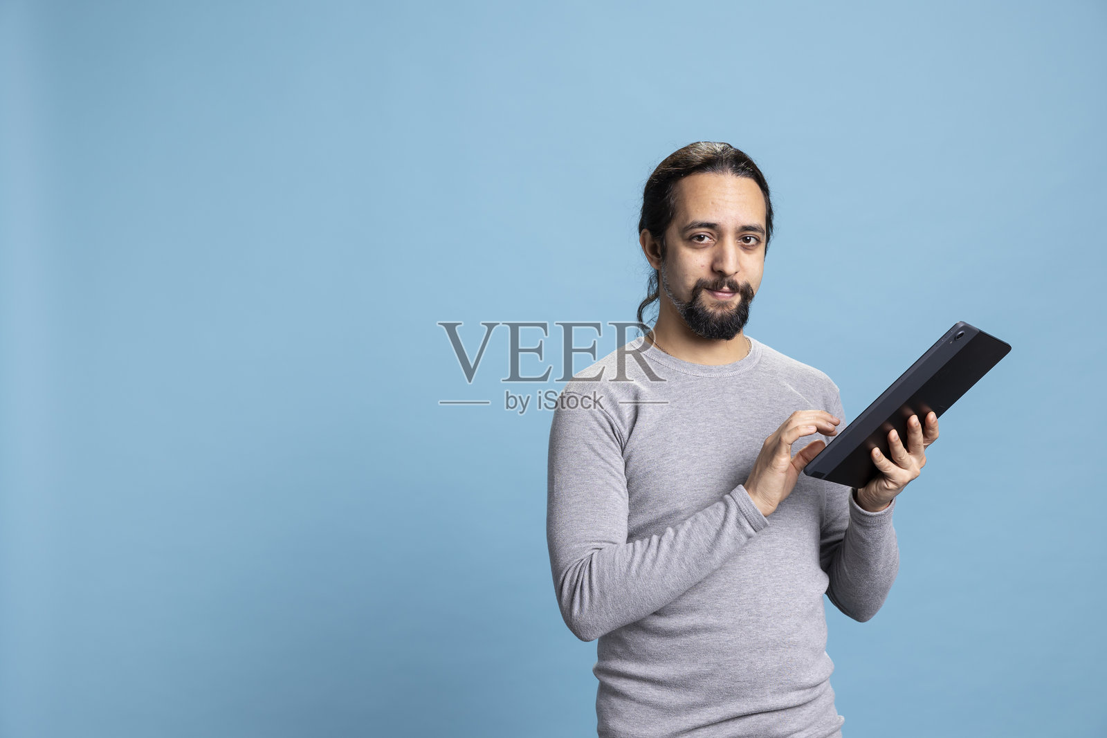 穿着休闲服的职业年轻男子，面带沉思表情使用笔记本电脑照片摄影图片