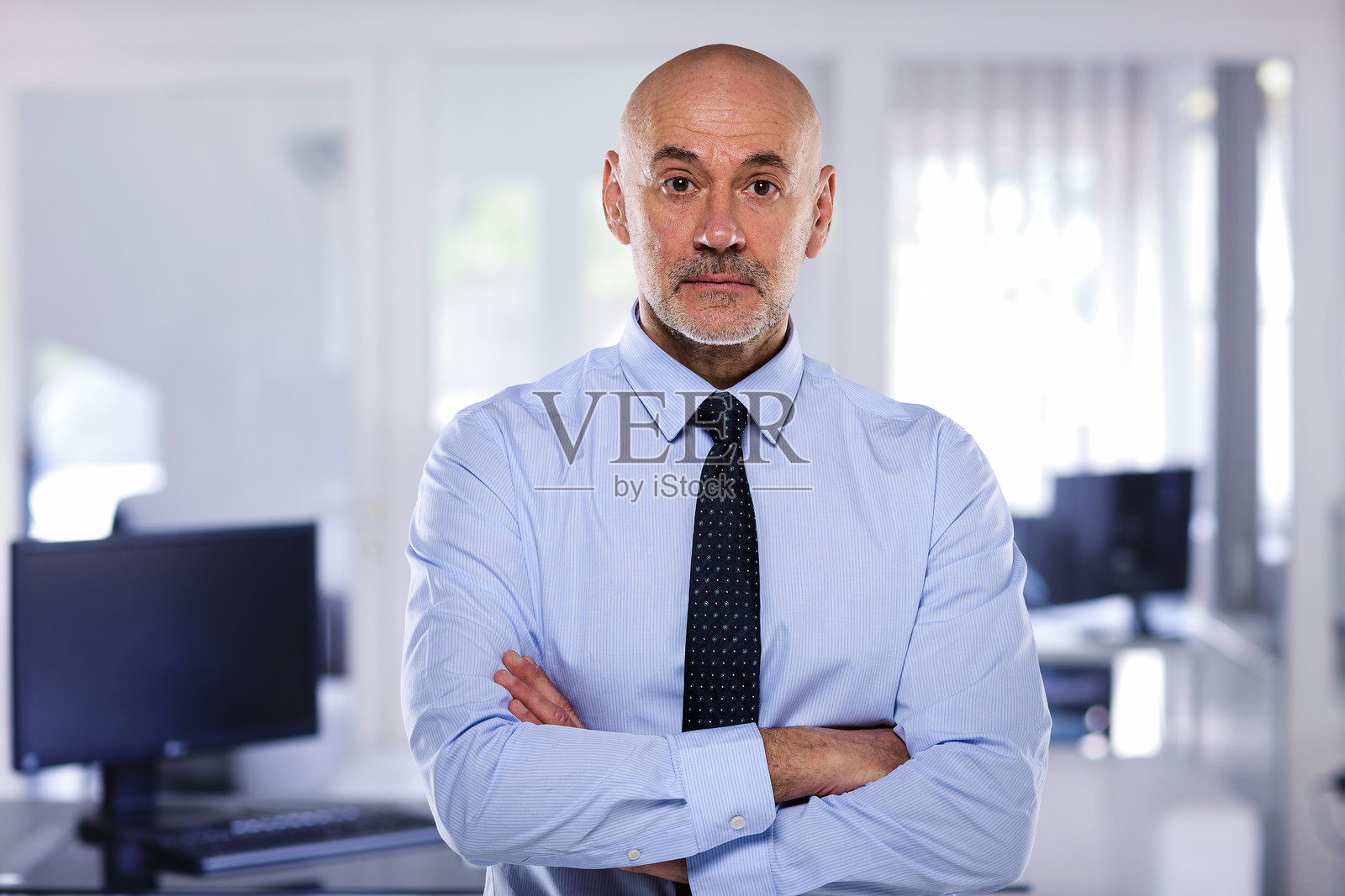 中年商人在现代办公室中站着并看向镜头照片摄影图片