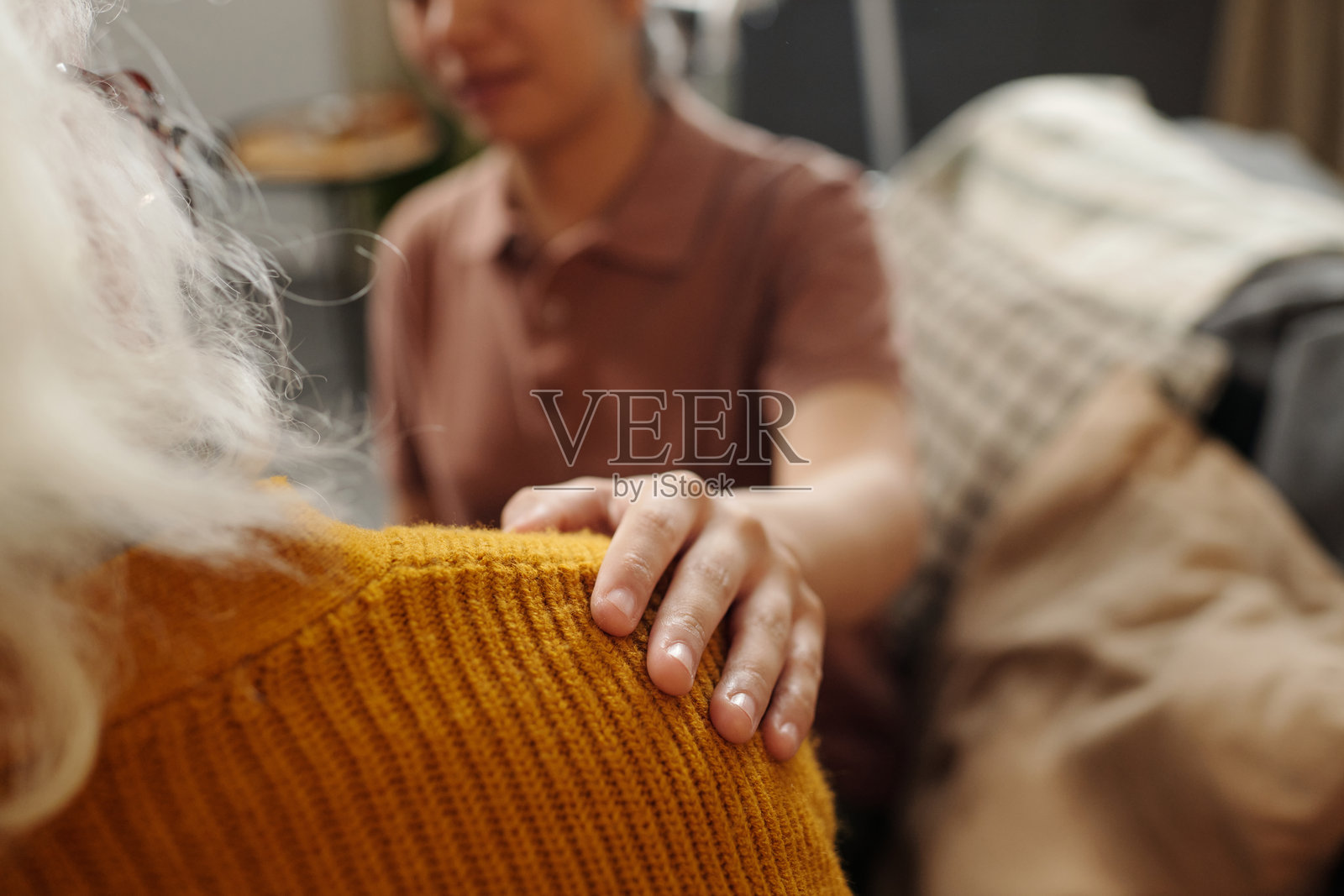 年轻的亚洲女性用温柔的触碰安慰年长的白人女性照片摄影图片