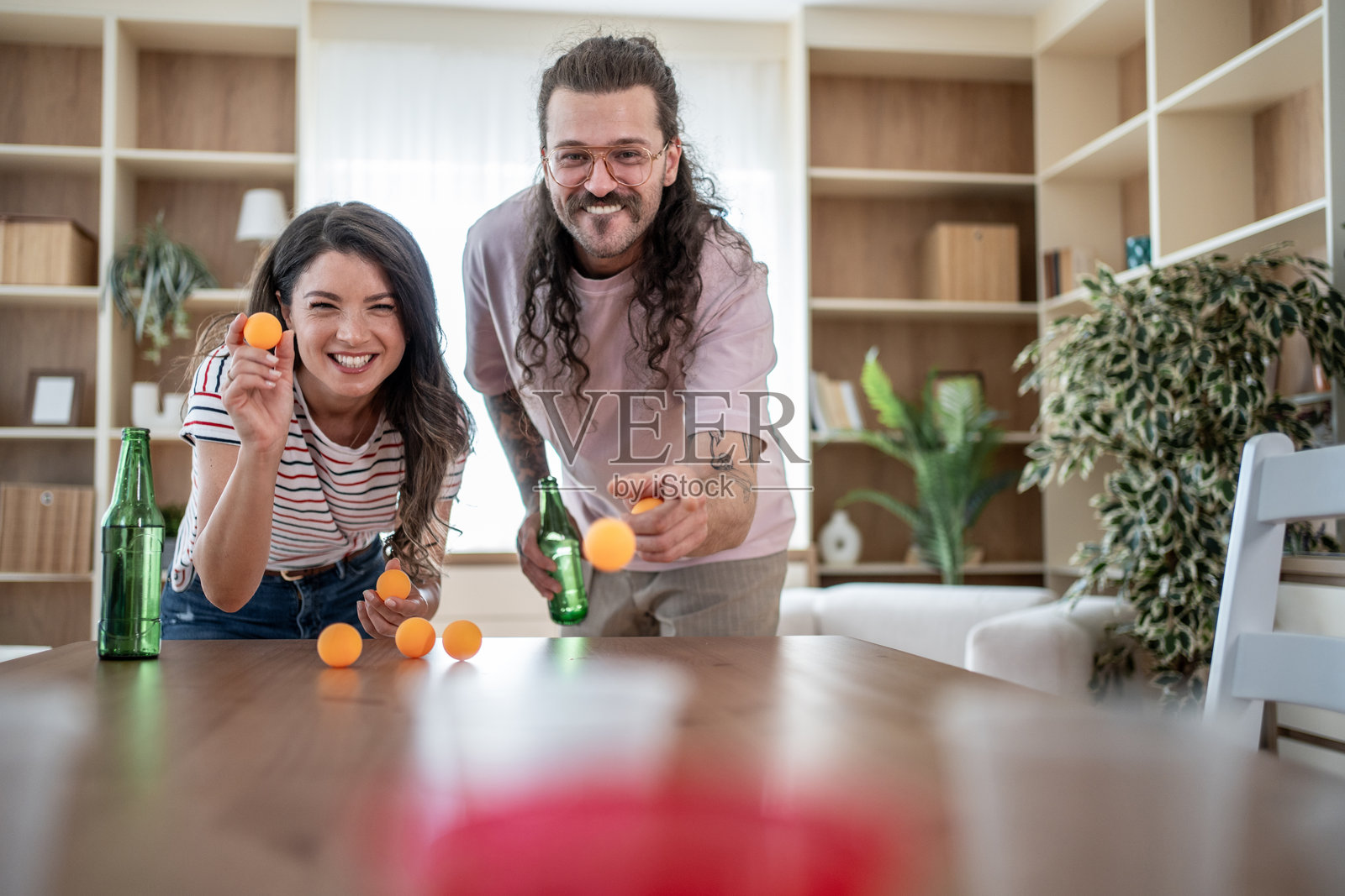 年轻情侣在家玩啤酒乒乓球游戏照片摄影图片