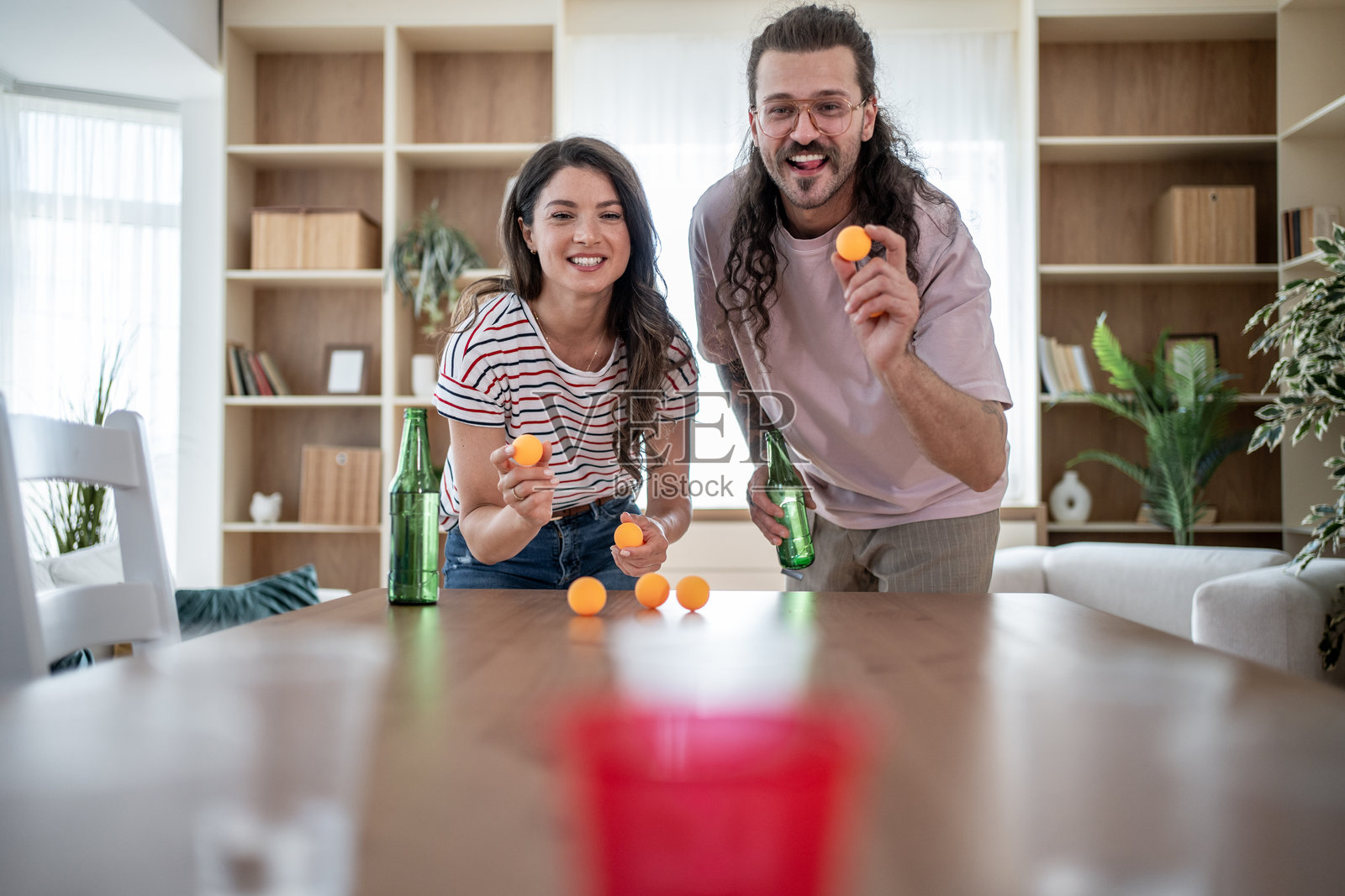 年轻情侣在家玩啤酒乒乓球游戏照片摄影图片