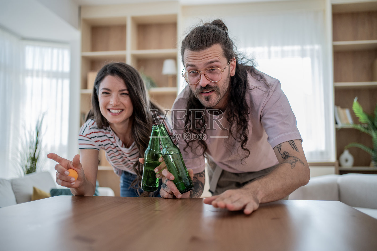 年轻情侣在家玩啤酒乒乓球照片摄影图片