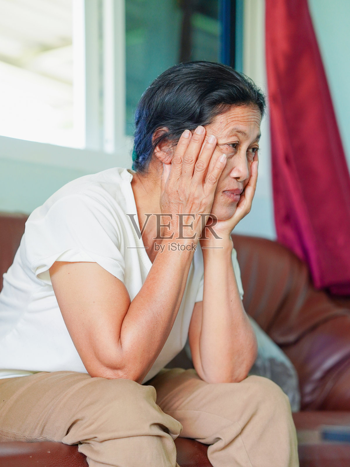 亚洲老年女性坐在沙发上感到头痛或发热照片摄影图片