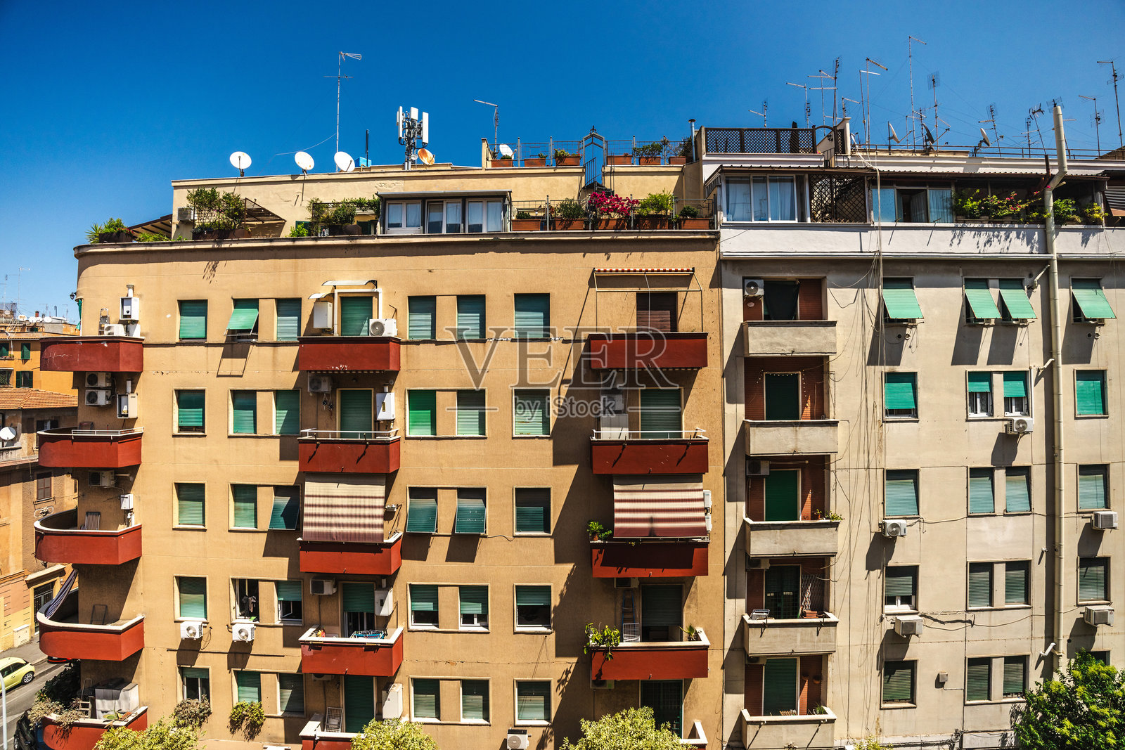 阳光明媚的意大利罗马，带阳台、百叶窗和屋顶天线的住宅建筑照片摄影图片