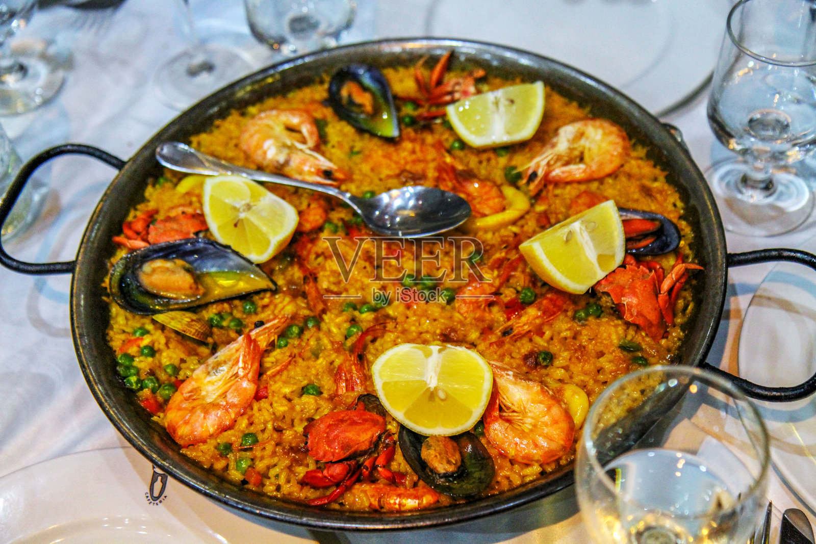 传统西班牙海鲜海鲜饭，配有虾、贻贝和柠檬照片摄影图片