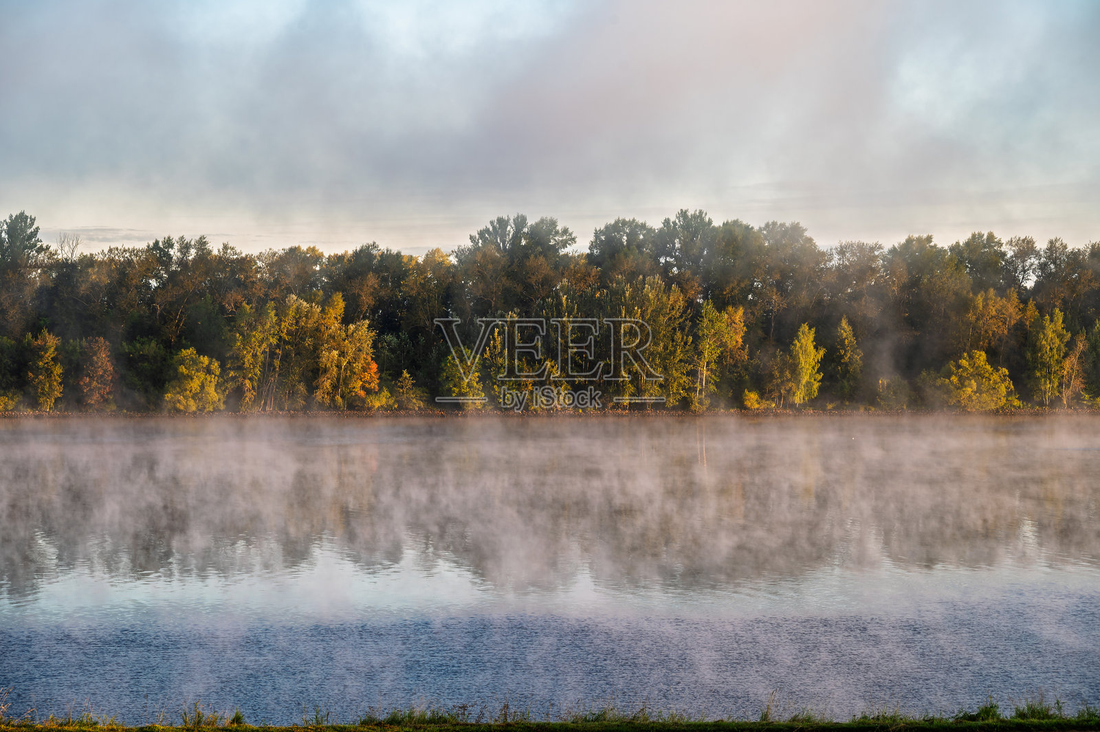 黎明时分河面上的雾气。照片摄影图片