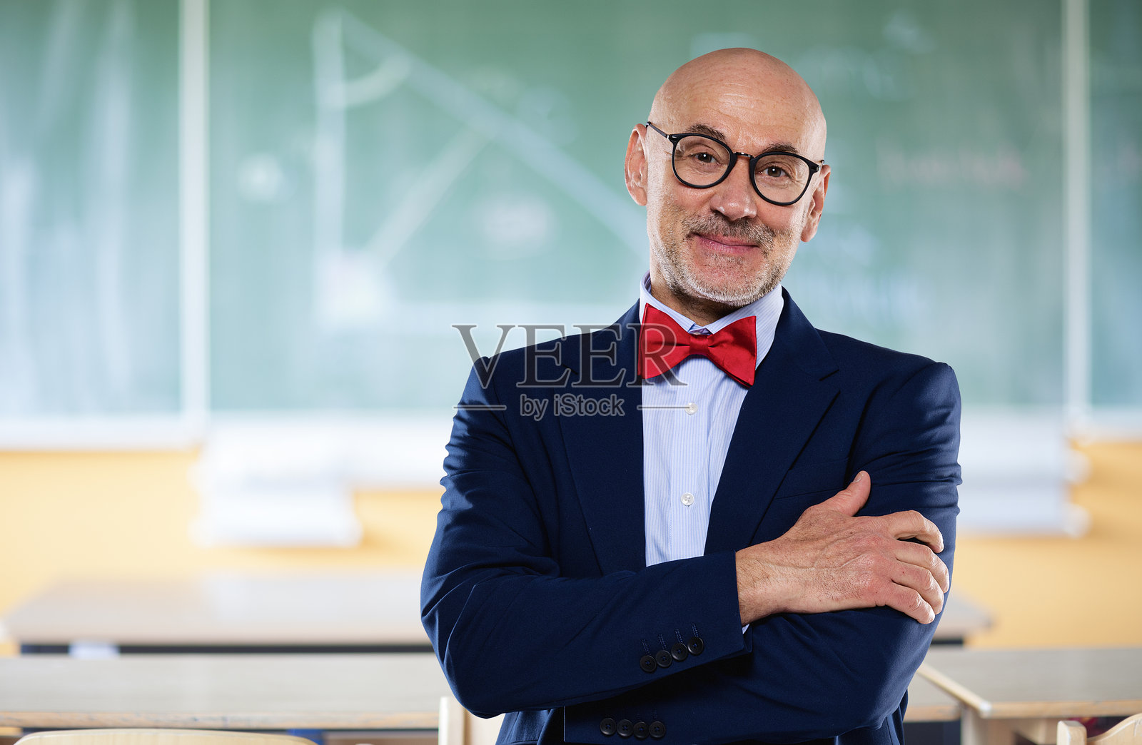 一位年长男性教授站在学校的黑板前的肖像照片摄影图片