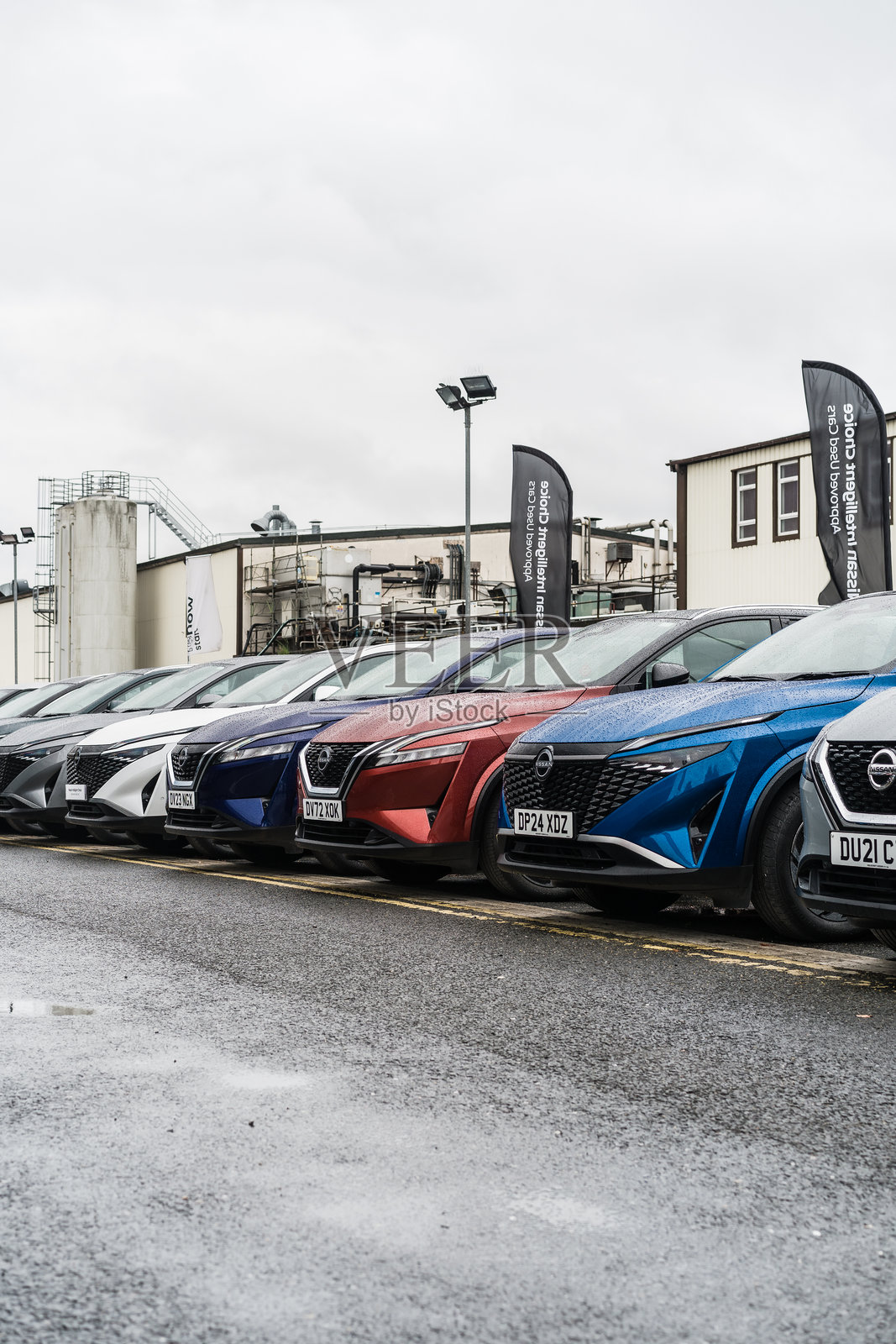 一排日产汽车停放在汽车展厅的前院。照片摄影图片