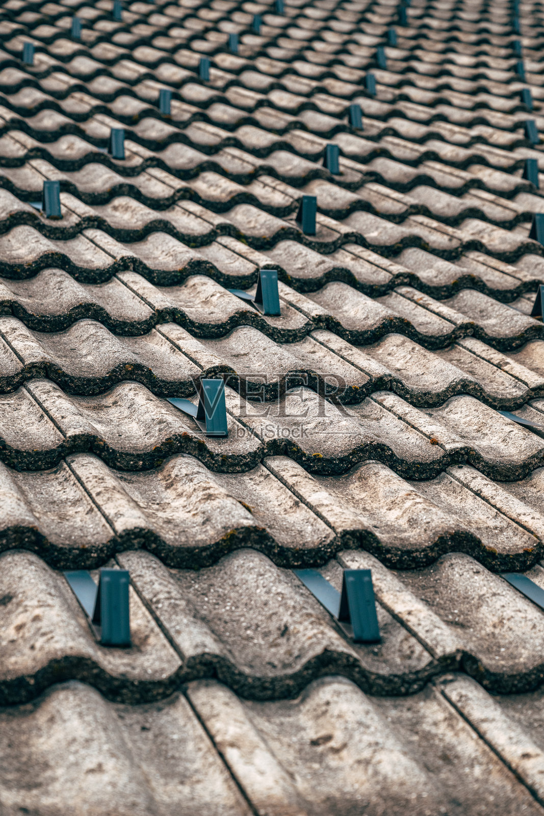 带有金属防雪挡板的瓦屋顶特写，展示了重复的图案和纹理表面。照片摄影图片