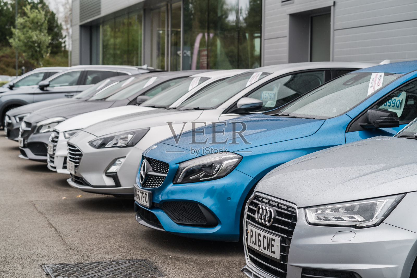 一排汽车停放在展厅前的广场上照片摄影图片