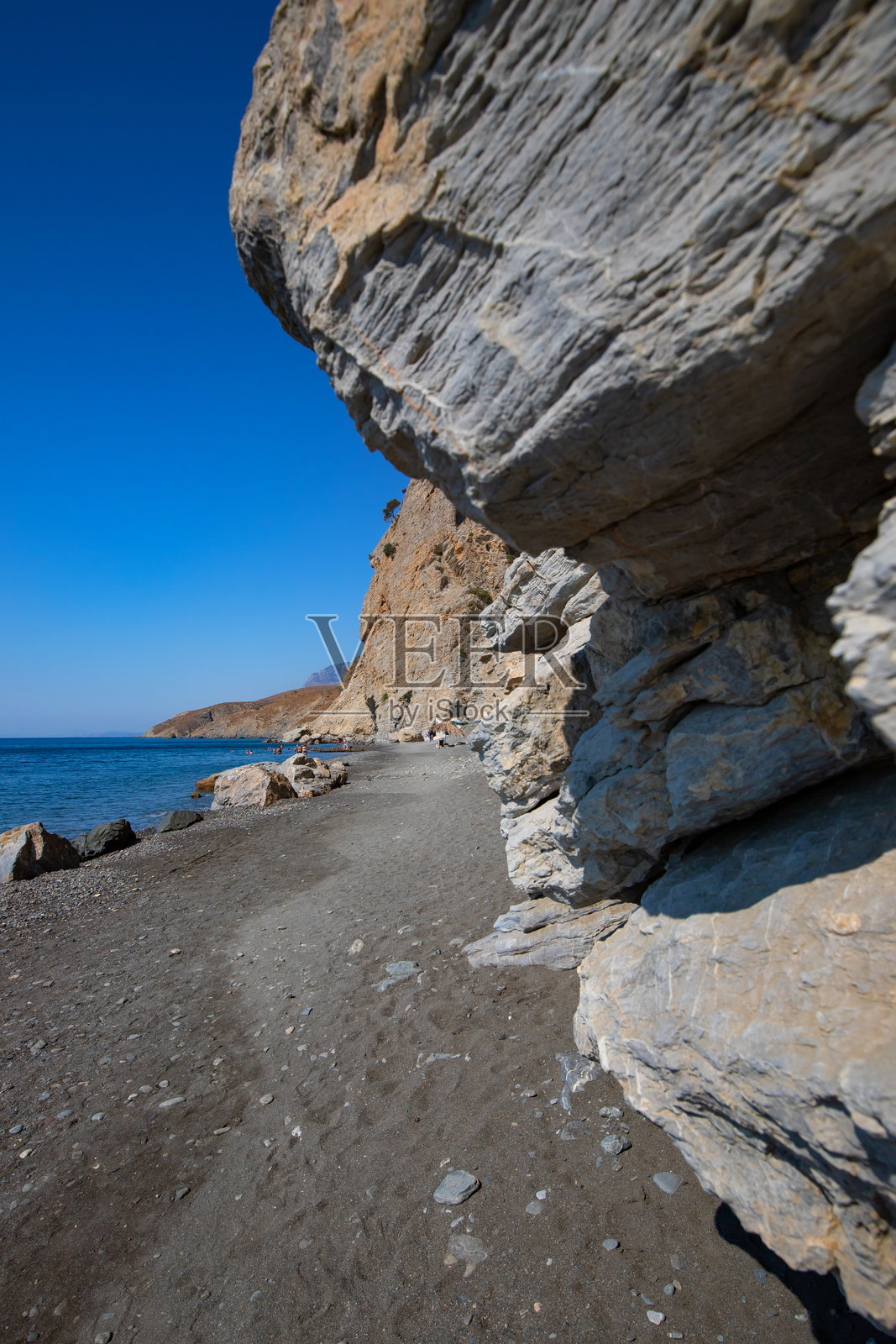 Embros Therma，一个有热温泉、悬崖和阳伞的阳光明媚的海滩照片摄影图片