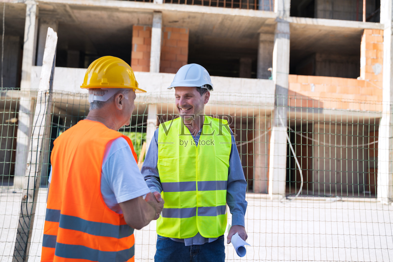 两名建筑工人在户外握手照片摄影图片